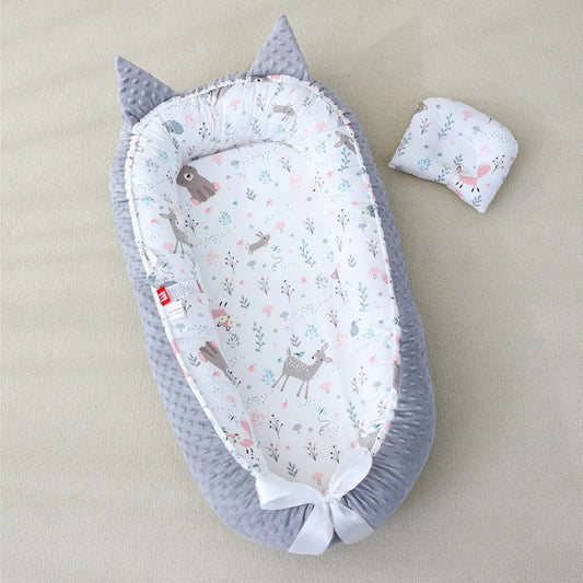Le cocon bébé bordure rose avec des motifs de cerfs