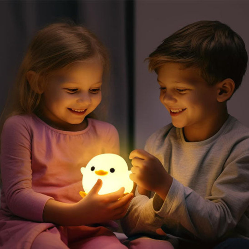 Les enfants qui jouent avec l veilleuse béé-canard