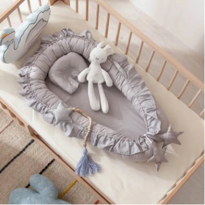 Le cocon bébé dans le berceau avec le doudou.