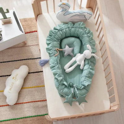 Le cocon bébé de couleur vert dans le berceau