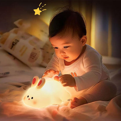 Bébé qui joue avec la veilleuse lapin 