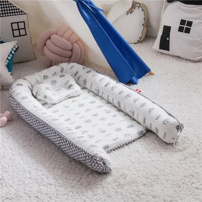 Un reducteur de lit bébé est posé au sol.
